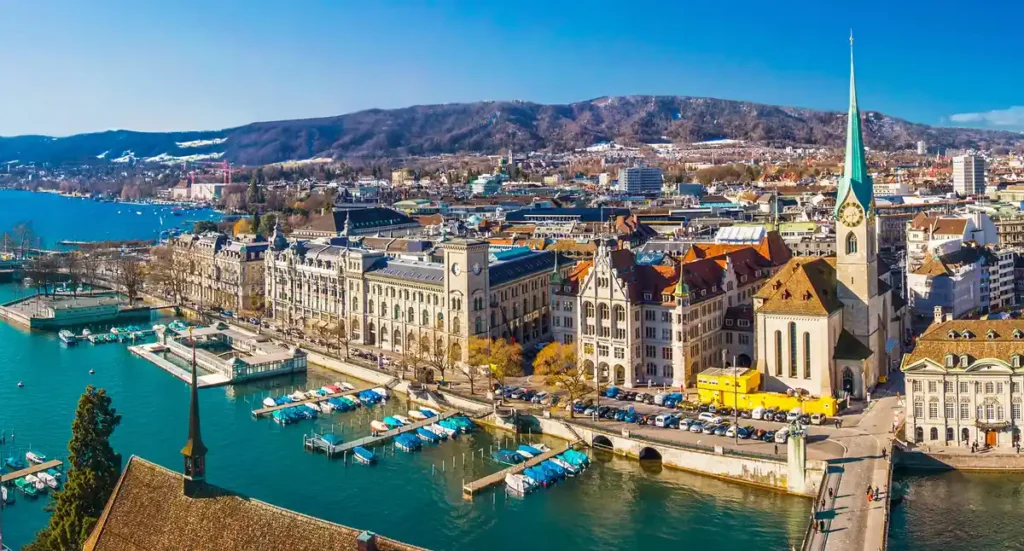Zurique reúne centro histórico, arquitetura suíça e paisagens à beira do lago, marcando o início e o encerramento deste pacote de viagem pela Suíça com trem Glacier Express.