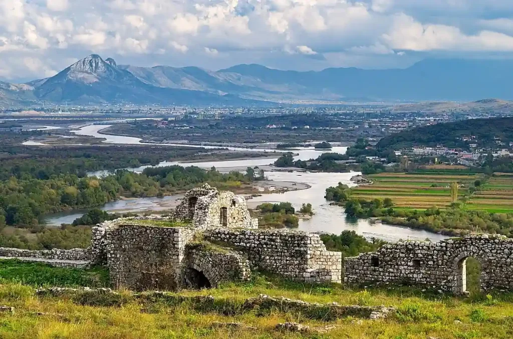 Castelo de Rozafa, uma das fortalezas históricas mais importantes da Albânia, localizado sobre uma colina próxima à cidade de Shkodër (Shkodra). A vista panorâmica revela a confluência dos rios Buna e Drin, as planícies verdes e as montanhas do norte albanês. Com origens que remontam à Antiguidade, a fortaleza oferece uma das paisagens mais impressionantes da região e é um dos principais pontos turísticos de Shkodër.