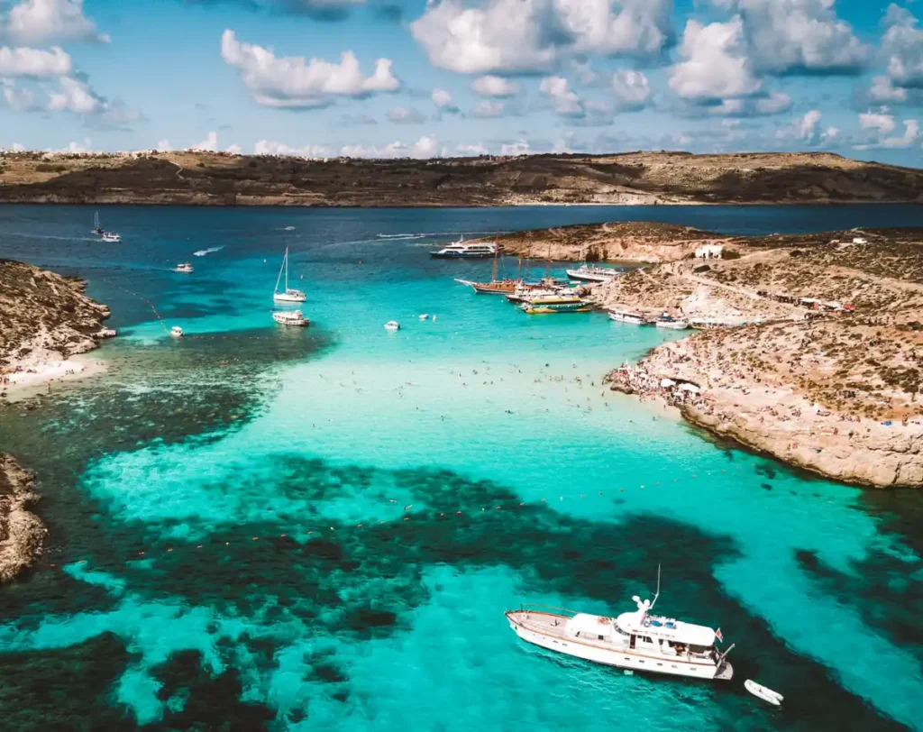 Blue Lagoon, na ilha de Comino, Malta, famosa pelas águas transparentes em tons de azul-turquesa. Localizada entre Malta e Gozo, a lagoa é um dos principais destinos para passeios de barco, mergulho e banhos de mar no Mediterrâneo, cercada por paisagens rochosas e pequenas enseadas.