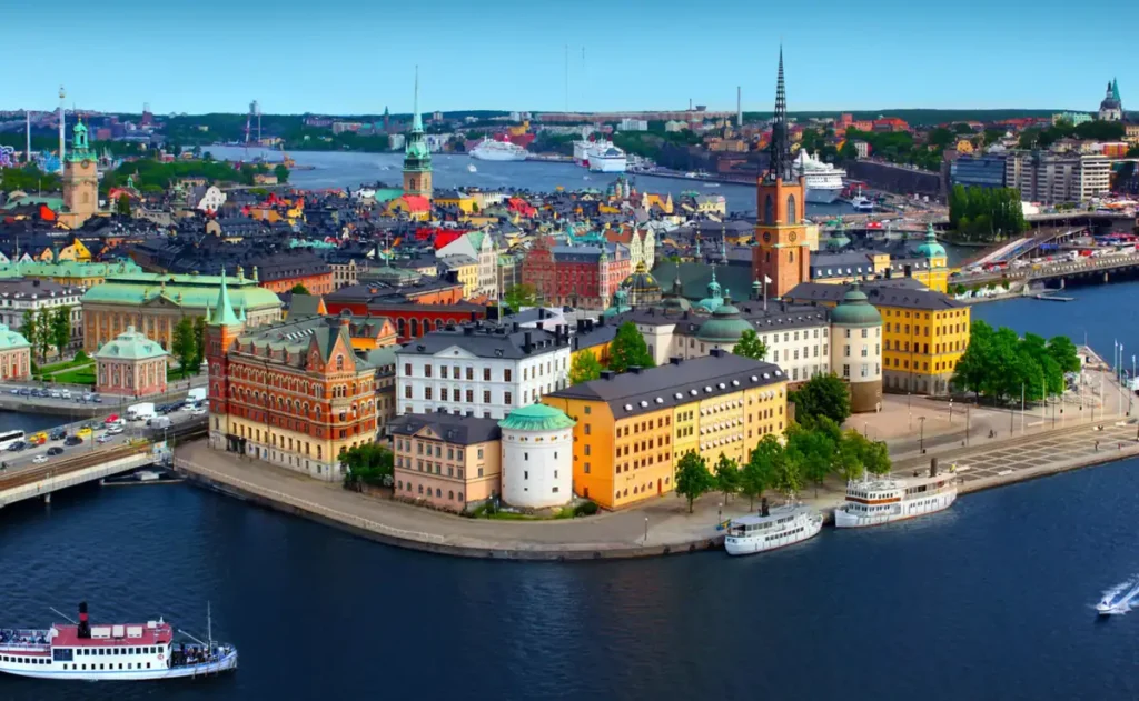 Panorama de Estocolmo com destaque para Riddarholmen e Gamla Stan, duas das áreas históricas mais emblemáticas da capital da Suécia. A fotografia mostra igrejas medievais, edifícios históricos, barcos navegando pelos canais e a paisagem formada pelas ilhas que caracterizam Stockholm.