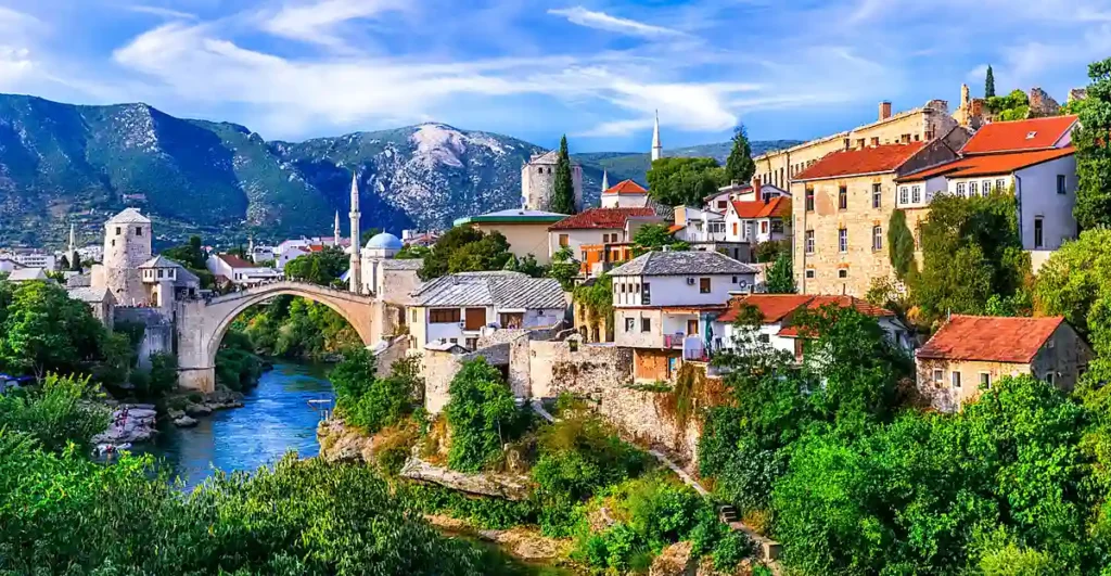 Vista panorâmica de Mostar, uma das cidades mais visitadas da Bósnia e Herzegovina. A paisagem reúne a histórica Ponte Stari Most, o rio Neretva de águas azuladas, mesquitas, construções otomanas e montanhas que cercam a cidade, formando um dos cenários mais emblemáticos dos Bálcãs.