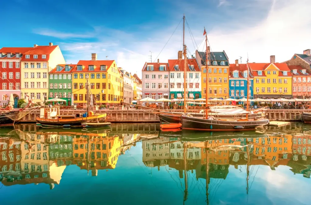 Nyhavn, o famoso porto histórico de Copenhague, na Dinamarca, conhecido pelas casas coloridas dos séculos XVII e XVIII, barcos tradicionais e restaurantes à beira do canal. Um dos cartões-postais mais fotografados da capital dinamarquesa, Nyhavn reúne arquitetura escandinava, história marítima e uma atmosfera animada no centro da cidade.