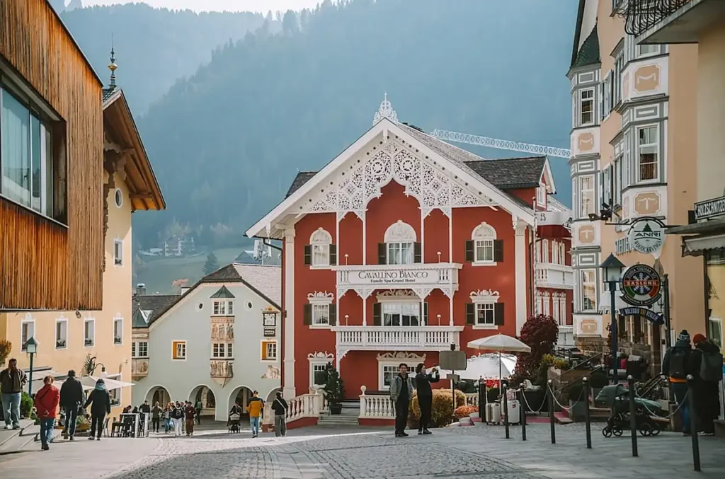 Ortisei (St. Ulrich), uma das vilas mais charmosas de Val Gardena, no Tirol do Sul, Itália. O centro da cidade reúne arquitetura alpina tradicional, hotéis históricos como o Cavallino Bianco, ruas agradáveis para passear e uma atmosfera típica das Dolomitas, sendo uma base popular para explorar as montanhas da região.