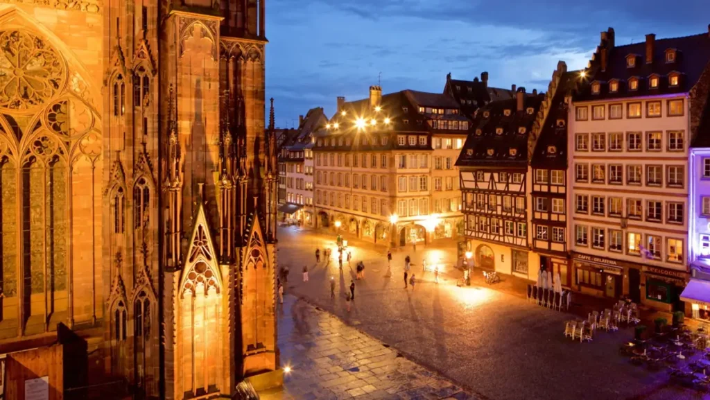 Catedral de Notre-Dame de Estrasburgo e sua praça histórica ao anoitecer. Um dos principais pontos turísticos da Alsácia, a catedral impressiona pela arquitetura gótica e pela atmosfera medieval do centro da cidade.