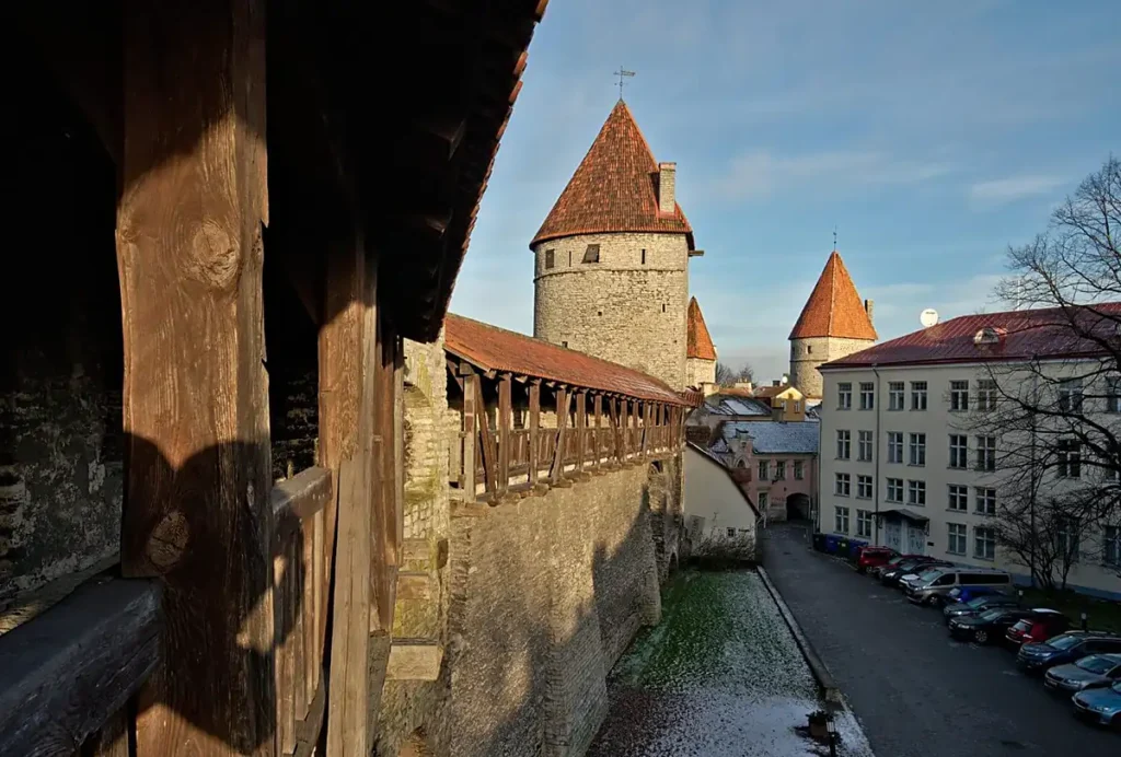 Muralhas medievais de Tallinn, um dos conjuntos de fortificações mais bem preservados do norte da Europa. A fotografia mostra a passarela defensiva de madeira e as torres de pedra que protegiam a cidade antiga da capital estoniana.